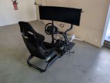 une photo d'un simulateur de course automobile dans un garage