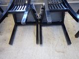 two black chairs sitting next to each other on the sidewalk