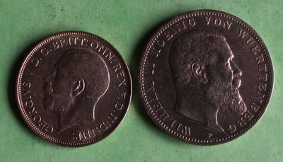 two coins are shown on a green surface, one is a man ' s head and the other is a