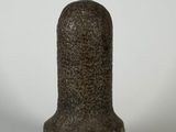 une image représentant un petit objet en pierre posé sur une surface blanche