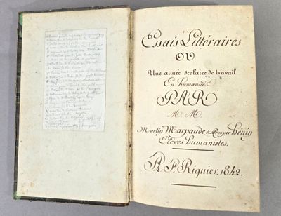 un livre ouvert, dont une page est recouverte d'une écriture manuscrite, posé sur une table