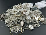 a pile of silver jewelry sitting on a table