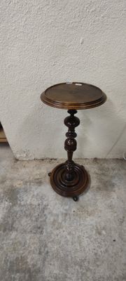 a small table with a wooden top on a concrete floor