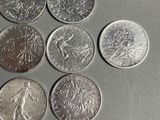six different types of coins are arranged in a circle on a table