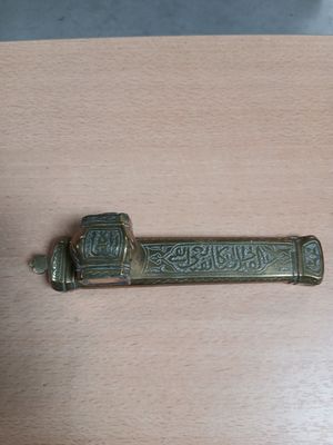une petite poignée de porte en laiton posée sur une table en bois