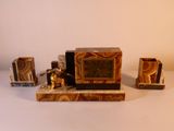 une petite horloge posée sur une table, à côté d'autres objets