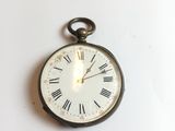 une horloge accrochée au mur avec des chiffres romains
