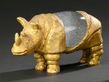 une figurine de rhinocéros dorée sur fond noir