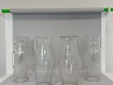 four empty glass vases sitting on a shelf