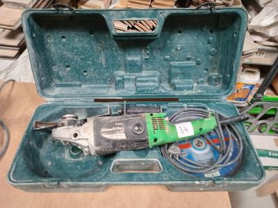 une boîte à outils verte contenant des outils, posée sur une table