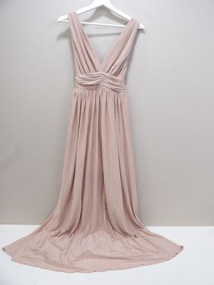 the back of a dress hanging on a hanger in front of a white wall