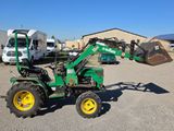 a green tractor with a bucket on the back of it