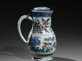 un vase bleu et blanc orné de fleurs et de feuilles