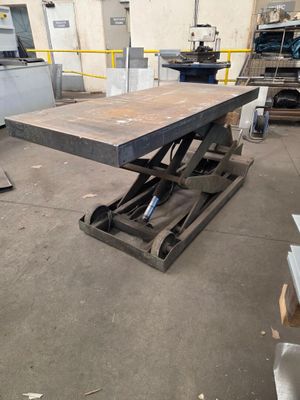 une table qui se trouve dans une pièce où il y a beaucoup d'outils