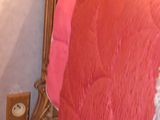 a bed that has a pink comforter on it
