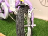 a purple bike that is sitting on a shelf