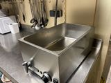a stainless steel sink sitting on a counter in a kitchen