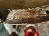 a close up of a piece of wood with a person standing in the background