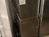 a silver refrigerator in a kitchen next to a white tiled wall