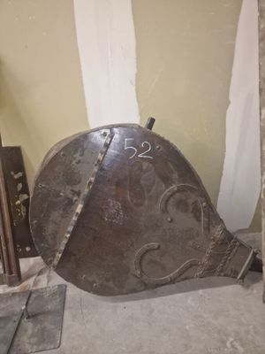un grand casque métallique posé par terre dans une pièce