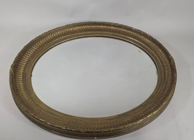 un miroir ovale avec un cadre doré sur fond blanc