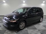 La Volkswagen Touran noire est garée sur un sol carrelé à damier.