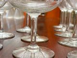 many empty wine glasses sitting on a wooden table