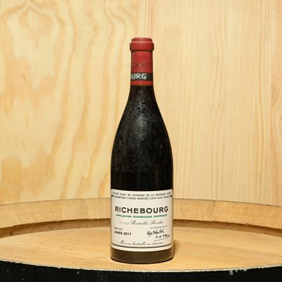 a bottle of wine sitting on top of a barrel