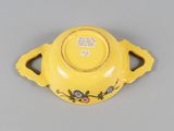 a small yellow bowl with a flower design on it