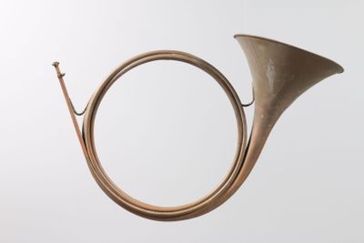 an old brass french horn on a white background