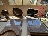 deux chaises et une table dans une pièce avec beaucoup de fenêtres
