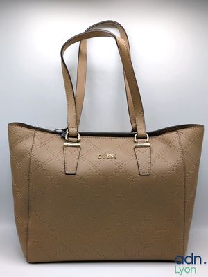 a close up of a tan handbag on a white background