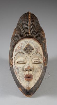 a close up of a wooden mask on a white surface