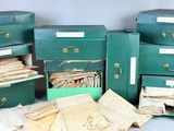 several green boxes with papers and papers are stacked on top of each other