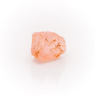 a close up of a pink rock on a white surface
