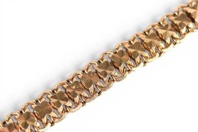 gold bracelet with a diamond cut design on a white background