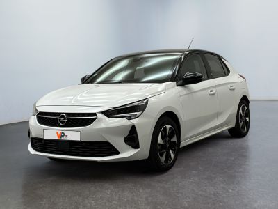 une Opel blanche garée dans une pièce au sol noir