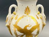 a white and gold vase with a light on it