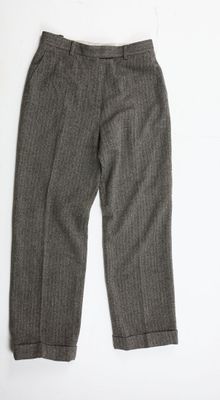 un gros plan du pantalon d'une personne posé sur une surface blanche