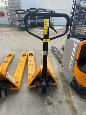 un chariot élévateur transportant deux palettes dans un entrepôt