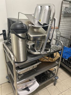 de nombreuses casseroles et poêles posées sur un chariot dans la cuisine