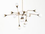 un lustre en laiton orné de globes en verre blanc suspendu au plafond