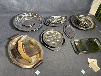 beaucoup d'assiettes et de casseroles en argent posées sur une table