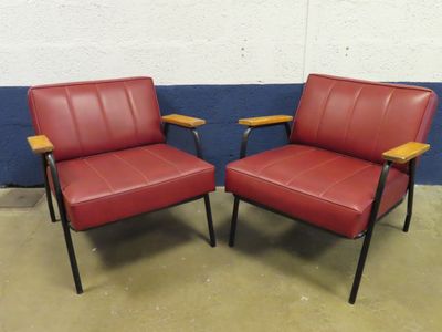 pair of red leather lounge chairs with black metal legs