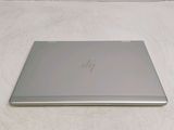 a laptop computer sitting on a bed with a white sheet