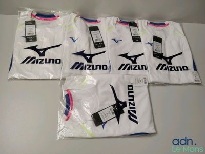 cinq t-shirts Mizuno dans des sacs en plastique posés sur une table