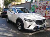 a white mazda cx - 3 parked on the side of the road