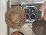 a mirror with coins hanging from it and a hand holding a coin