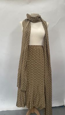 beige and white polka dot dress and scarf on a mannequin dummy