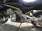 a black motorcycle parked in a parking lot next to other motorcycles